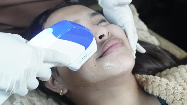 Female patient receiving HIFU treatment at an aesthetic clinic for jawline lifting, skin tightening and facial contouring