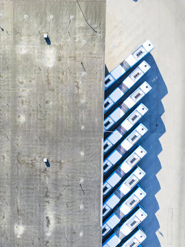 Aerial view of a row of buses parked in a line next to a large industrial building roof in Gothenburg, Vastra Gotaland County, Sweden.