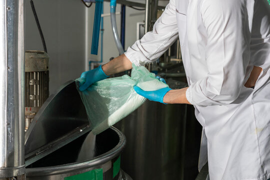 Man pouring Flour In Mixing Machine in industrial factory. Middle-aged manager with expertise