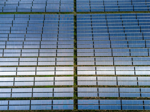Aerial view of a large solar thermal farm with rows of panels arranged in a grid pattern across the landscape in Germany.