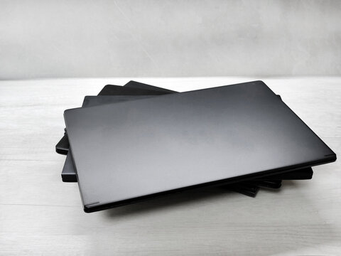 stack of laptops on a gray background, on the table, laptop computer, tablet, business, work, remote work, freelance.
