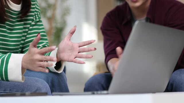 oung asian couple using laptop computer, talking and working at home.