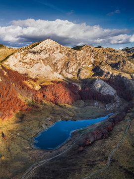 Aerial view of Sutjeska National Park featuring a serene mountain lake surrounded by vibrant autumn foliage and rugged peaks in Tjentiste, Republika Srpska, Bosnia and Herzegovina.