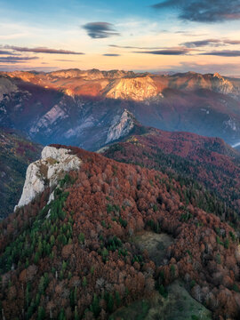 Aerial view of Sutjeska National Park with autumn foliage on mountain slopes and rugged rocky peaks under golden hour light in Tjentiste, Republika Srpska, Bosnia and Herzegovina.
