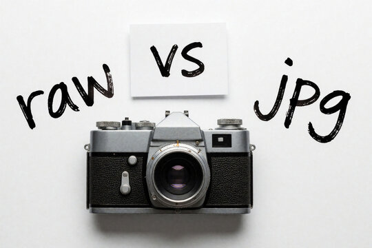 Vintage camera displays RAW vs JPG file formats. Photographer compares image capture options, file quality, and editing flexibility for better results.