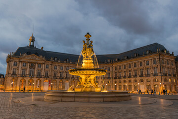 Obraz premium Beleuchteter Brunnen der Drei Grazien am Place de la Bourse, Bordeaux, Frankreich