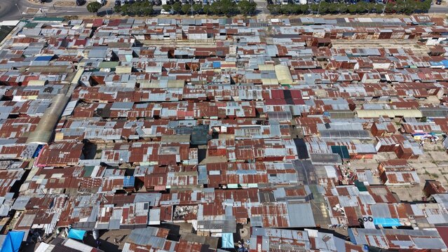 Aerial view of a dense outdoor market with numerous small stalls featuring rusted corrugated metal roofs in Pancevo, Serbia.