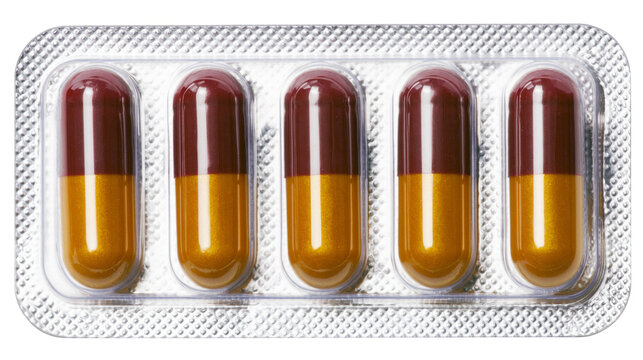 Five brown and gold capsules in a silver blister pack, isolated on transparent background