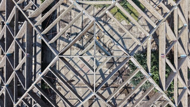 Aerial view of a complex wooden roof truss structure with geometric patterns and exposed beams in Pancevo, Serbia.