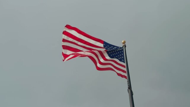 Static shot of an American flag actively waving in moderate slow motion.