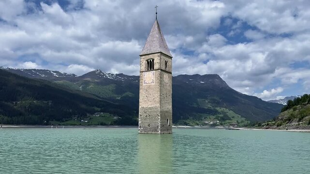 Static view of the submerged Curon bell tower at Lake Resia gradually changing from black and white to natural color.
