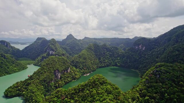 Cinematic drone footage showcasing Dayang Bunting Lake, also known as the Lake of the Pregnant Maiden, surrounded by lush limestone mountains deep within Langkawi's UNESCO Global Geopark.