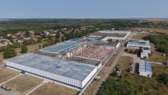 Aerial view of the industrial facility in the Severna zona industrial park with large warehouse buildings and surrounding green fields in Pancevo, Serbia.