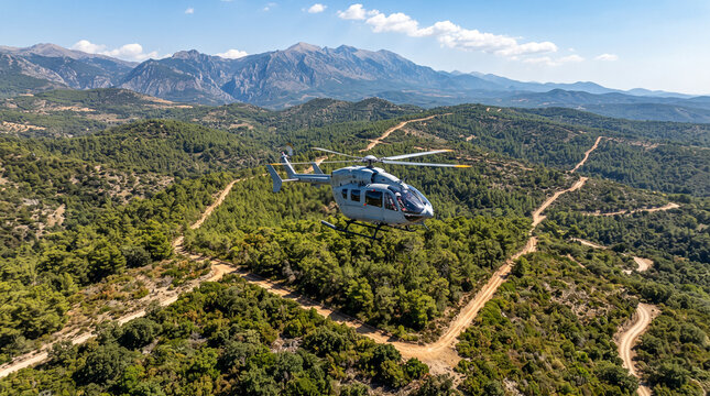 Helic&oacute;ptero sobrevolando un bosque mediterr&aacute;neo para vigilar y prevenir incendios forestales, mostrando gesti&oacute;n y protecci&oacute;n del territorio.