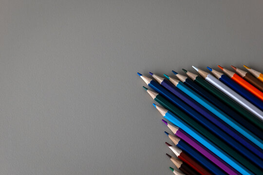 Colorful Pencils Form an Arrow Beside Generous Copy Space