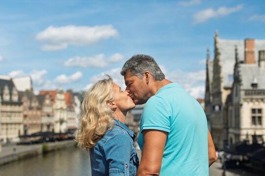 Couple kissing on a bridge above a historic canal