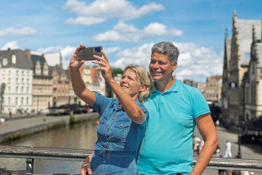 Tourists taking a selfie above a historic canal