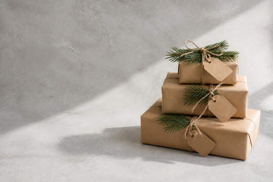 Three gifts wrapped in unprinted kraft paper and tied with natural