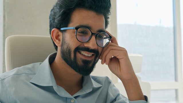 Smiling Indian Arabian business man working laptop at office typing project satisfied male businessman entrepreneur ethnic CEO executive manager employer achievement computer desktop success indoors