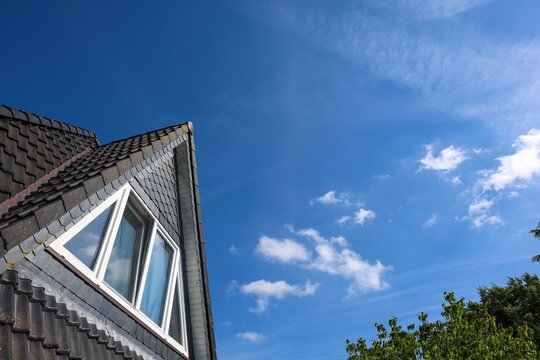 House roof dormer window under clear blue sky