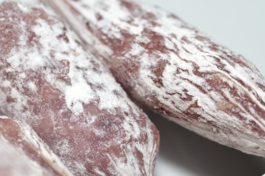 Close-up of delicious dry cured sausages with natural white mold covering the casing