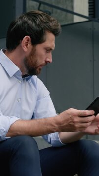 Serious Caucasian mature businessman using smartphone in city searching vacancy sad business man looking dismissal box fired unemployed male lost work think browsing mobile phone outside office stairs