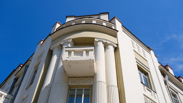 A white balcony on the corner of the house, a summer day.