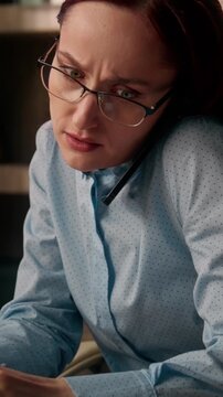 Busy Caucasian business woman multitasking writing notes talking phone work laptop inside office anxious businesswoman female entrepreneur manage tasks online deadline pressure planner consulting call