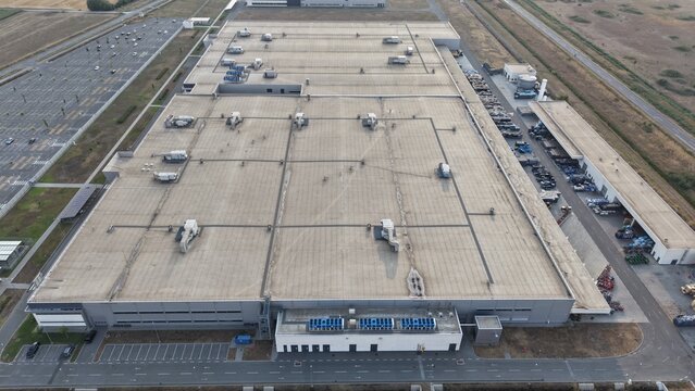 Aerial view of the Severna zona industrial facility featuring a large flat roof with HVAC units, an adjacent parking lot, and loading areas in Pancevo, Serbia.