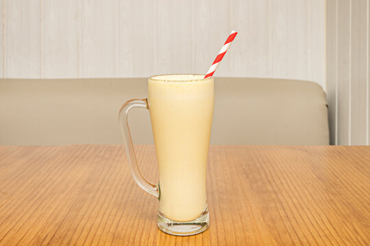 Vanilla Milkshake in Handled Glass Mug with Red-and-White Striped Straw