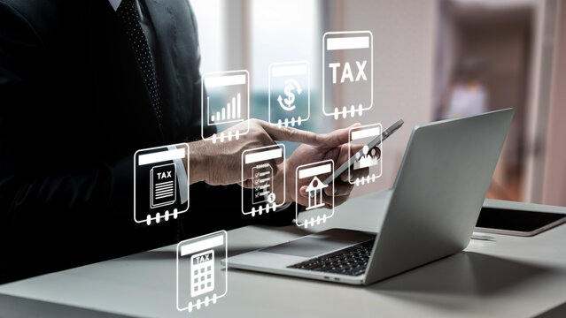 Businessman using laptop and tablet to manage online tax filing with digital financial icons. Concept of a Tax Consultant
