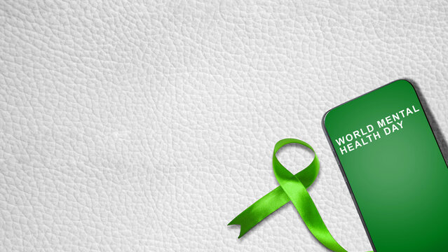 Smartphone displaying World Mental Health Day text next to a green awareness ribbon on a white leather background with copy space. Concept of World Mental Health Day