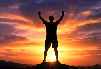 Fototapeta premium Silhouette of a triumphant person standing on a mountain top at sunset with arms raised in victory