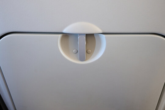 Close-up of a fold-down tray table on a passenger airplane seat.