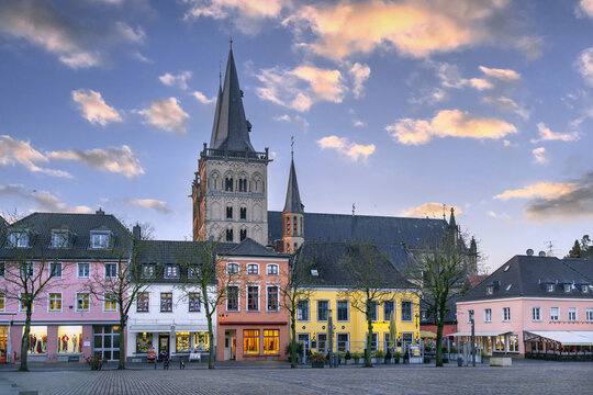 Historic houses on main square with Xanten Cathedral behind, Germany. Sunset sky with warm evening light