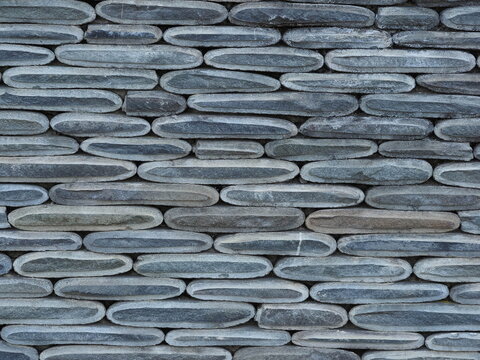 Texture of a fence made of decorative stonework made of gray sea pebbles