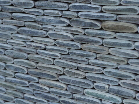 Texture of a fence made of decorative stonework made of gray sea pebbles