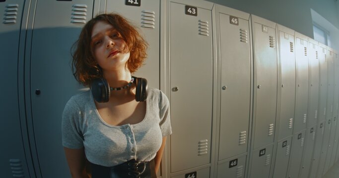 Thoughtful Teenage Girl With Calm, Slightly Distant Gaze Standing in High School Hallway Near Lockers. Creative Gen Z Youth, Individuality, Quiet Reflection and Authentic Adolescent Lifestyle.