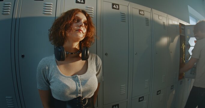 Thoughtful Teenage Girl With Calm, Distant Gaze in High School Hallway Near School Lockers. Introspective Gen Z Youth, Creative Identity, Individuality and Quiet Reflection During Adolescence.