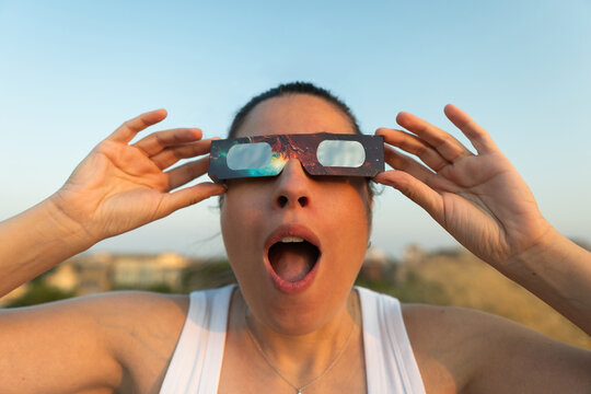 Woman experiencing solar eclipse with protective glasses