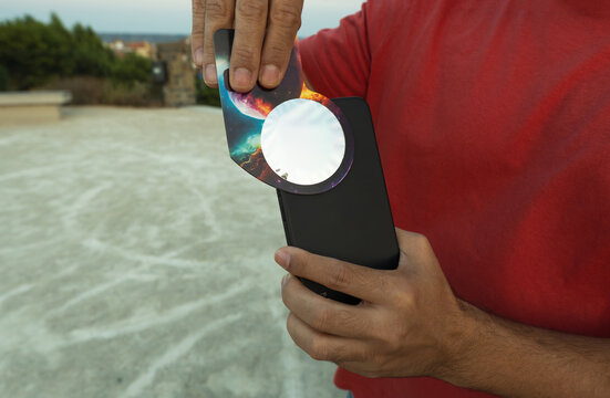 Person using solar filter on smartphone for celestial viewing