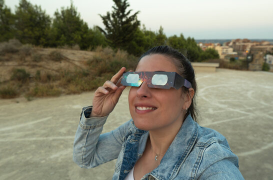 Woman observing celestial event with eclipse glasses