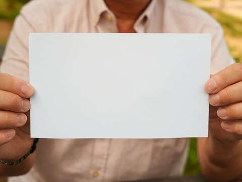Person Holding Blank Sign Outdoors with Copy Space