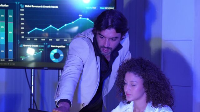 Business professionals analyzing revenue and growth analytics on digital display, representing business intelligence, data analytics, financial growth, teamwork, strategy, and digital transformation.
