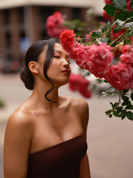 Asian Woman Smelling Pink Roses Eyes Closed Outdoors