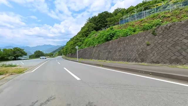 Motorcycle POV on an open road under a big summer sky