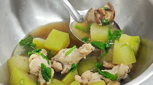 Cooking Thai winter melon soup with chicken in steel pot.
