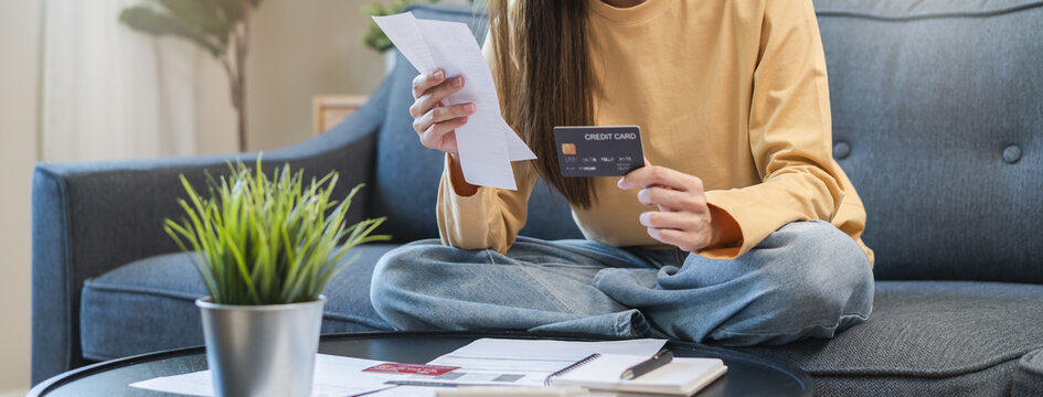 Asian woman looking at many credit cards in her hand and worried about loan debt pay late