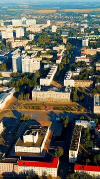 Vertical video. Oryol, Russia. The House of Soviets, a Soviet-era administrative complex with a geometric facade and central toweramid a grid of residential blocks and tree-lined avenues, clear summe