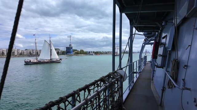 View from naval frigate deck looking at sailing schooner during Hanse Sail festival in Warnemunde port, Rostock.